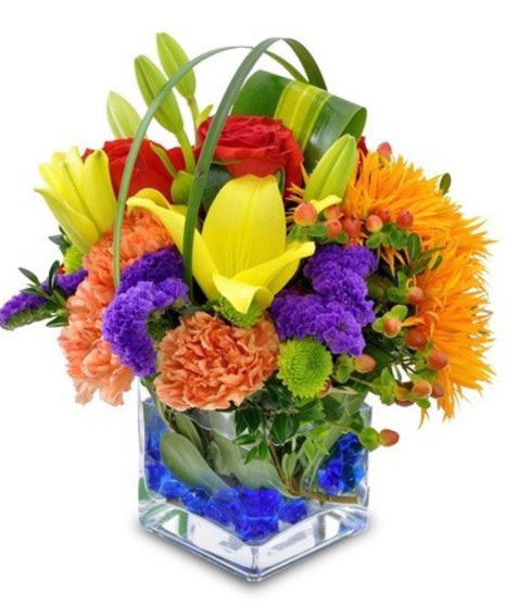 Colorful Cube is a bright mix of gerbera daisies, carnations, lilies, and more in a compact cube vase with colored gems.