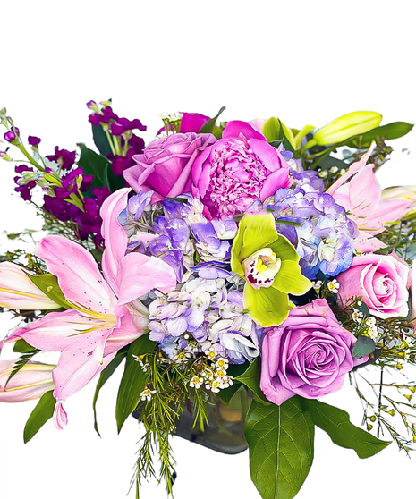 Peony Paradise is Fragrant pink peonies, lavendar roses and lilies are compact and arranged with hydrangea for a pastel look in a compact vase design