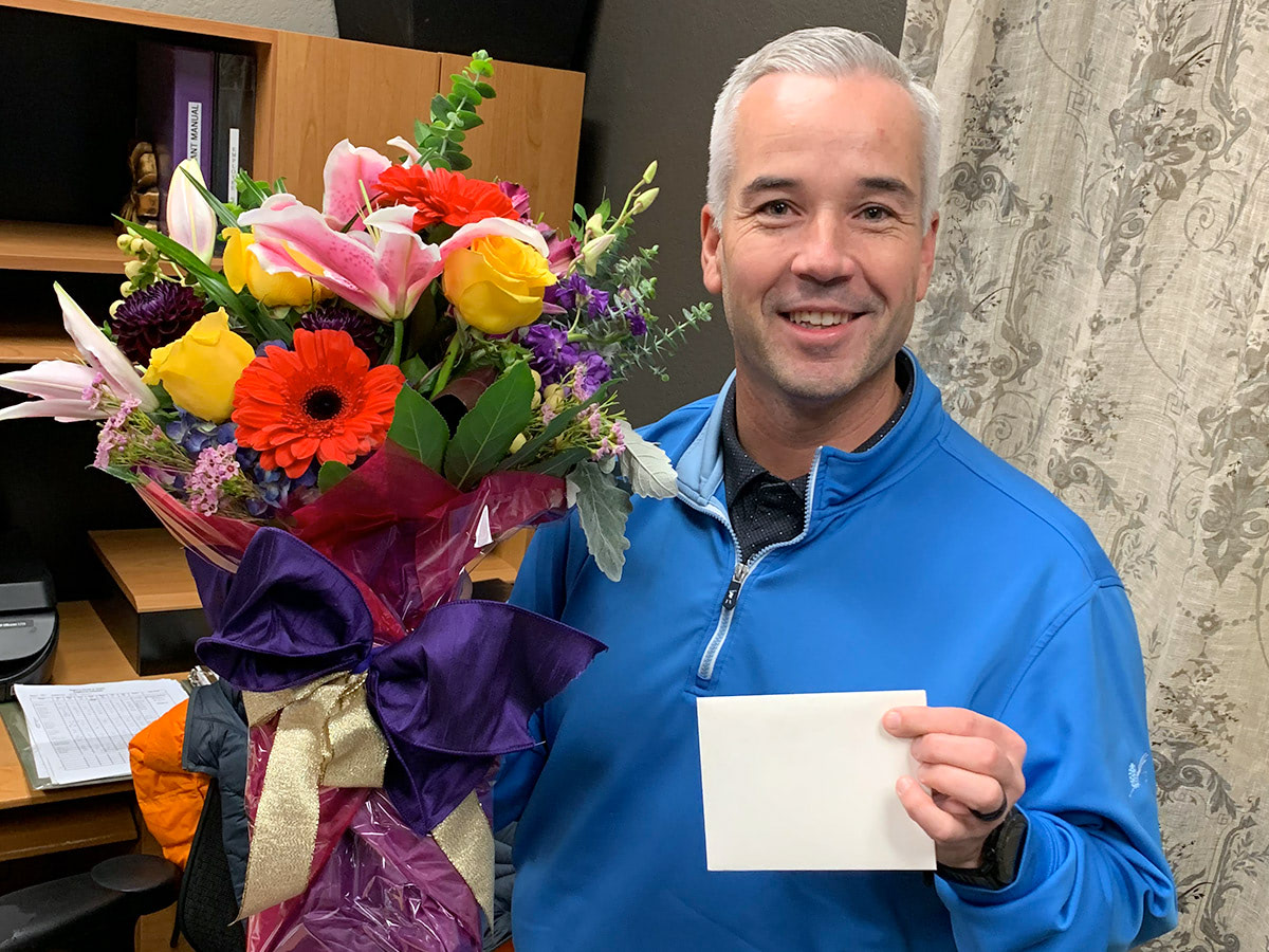 Adam proudly displays a striking bouquet, full of life and lush colors