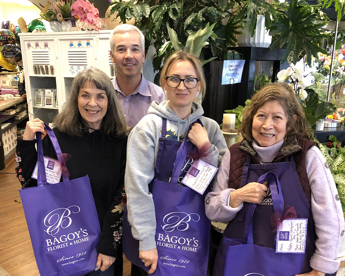 Four of our favorite employees model with our branded shopping bags