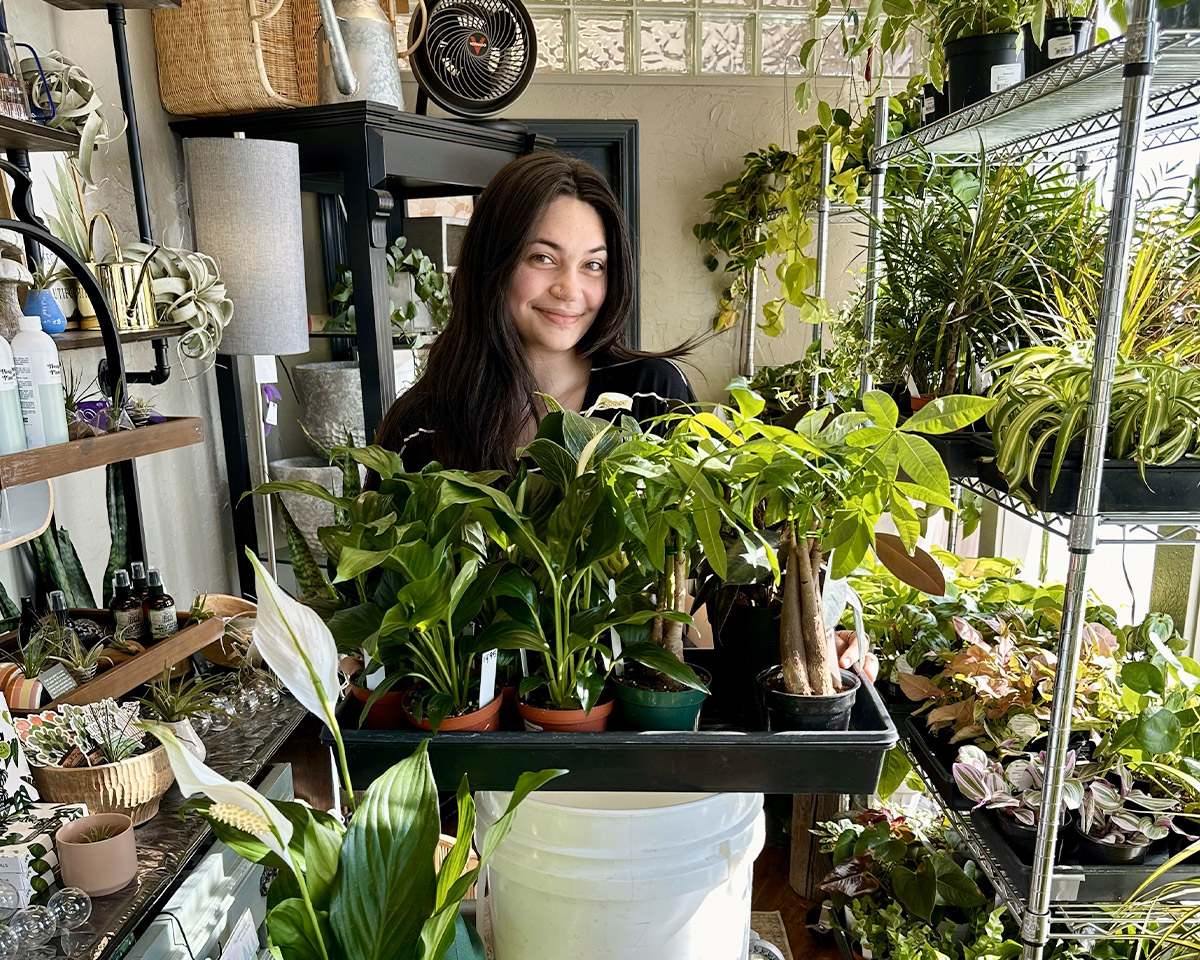 An employee stocks the greenhouse with fresh plants