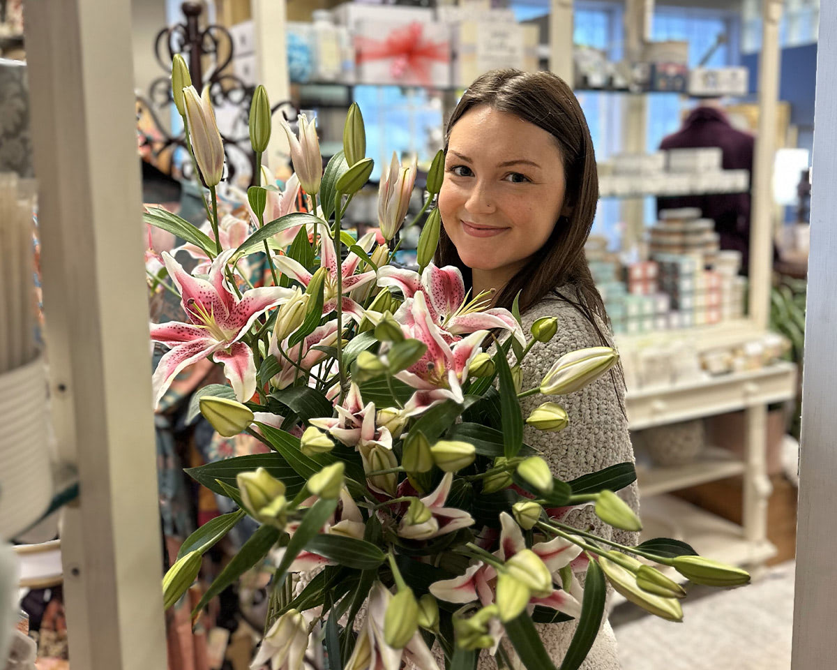 A gorgeous pink and white orchid arrangement look stunning in the arms of a Bagoy's employee